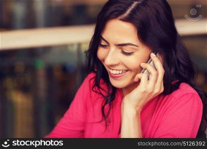 leisure, technology, lifestyle, communication and people concept - happy woman calling on smartphone at restaurant. happy woman calling on smartphone at restaurant