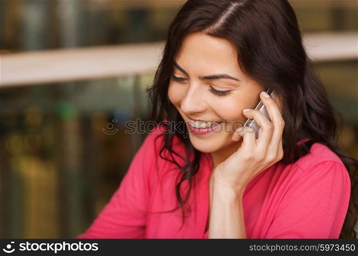 leisure, technology, lifestyle, communication and people concept - happy woman calling on smartphone at restaurant