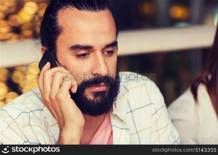 leisure, technology, lifestyle, communication and people concept - sad man calling on smartphone at restaurant. sad man calling on smartphone at restaurant