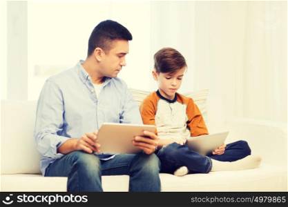 leisure, technology, technology, family and people concept - father and son with tablet pc computer networking or playing at home. father and son with tablet pc at home
