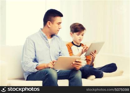 leisure, technology, technology, family and people concept - father and son with tablet pc computer networking or playing at home. father and son with tablet pc at home