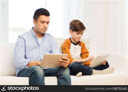 leisure, technology, technology, family and people concept - father and son with tablet pc computer networking or playing at home