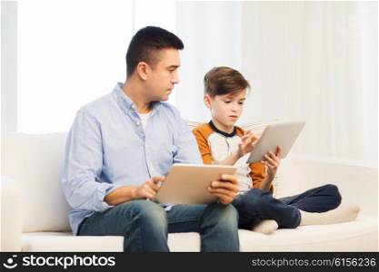 leisure, technology, technology, family and people concept - father and son with tablet pc computer networking or playing at home