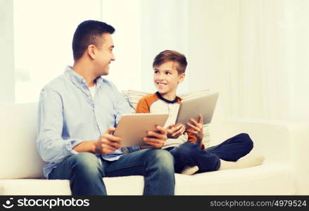 leisure, technology, technology, family and people concept - happy father and son with tablet pc computer networking or playing at home. happy father and son with tablet pc at home