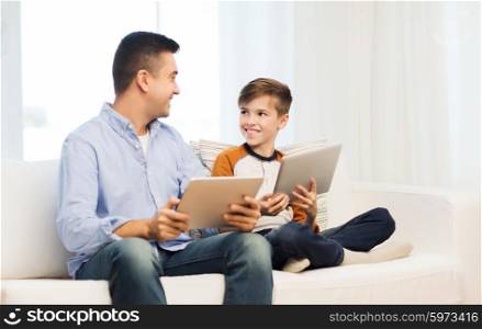 leisure, technology, technology, family and people concept - happy father and son with tablet pc computer networking or playing at home