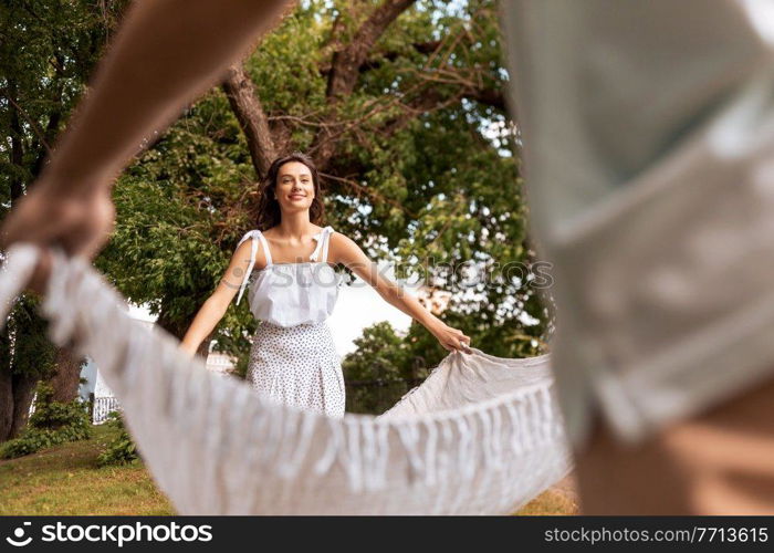 leisure, vacation and people concept - happy couple laying picnic blanket at summer park. happy couple laying picnic blanket at summer park