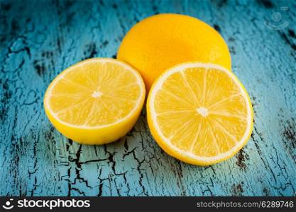 Lemon and cut half slice on blue wooden background