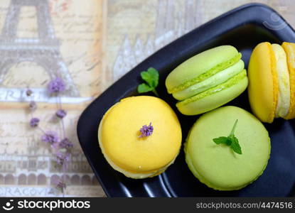 Lemon and mint flavor french macarons on black plate