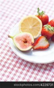 lemon, fig and strawberries on a plate