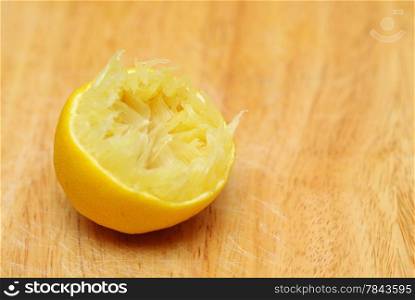 Lemon fruit half queezed on old wooden table kitchen cutting desk board background. Healthy food organic nutrition