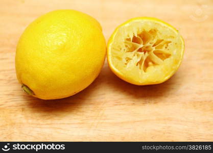 Lemon fruits fresh and half queezed on old wooden table kitchen cutting desk board background. Healthy food organic nutrition