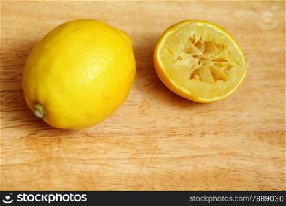 Lemon fruits fresh and half queezed on old wooden table kitchen cutting desk board background. Healthy food organic nutrition