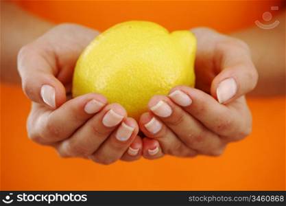 lemon in woman hands close up