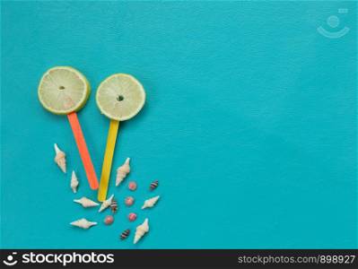 Lemon juice and shell on blue background beach. Flat mock up for design.