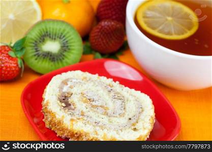 lemon,lemon tea,mandarin,kiwi,cake and strawberries lying on the orange fabric