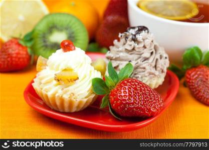 lemon,lemon tea,mandarin,kiwi,cake and strawberries lying on the orange fabric
