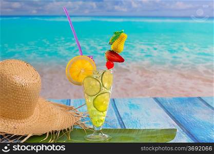 Lemon lime cocktail mojito on tropical turquoise beach on blue wood