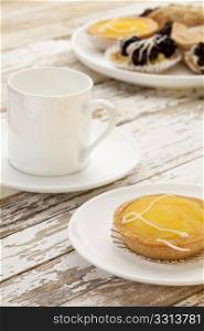 lemon mini tart and espresso coffee on a rustic wooden table
