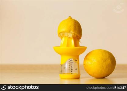 Lemon placen on juice squeezer maker, making citrus sour drinks. Studio shot on grey background.. Lemon placen on juice squeezer maker