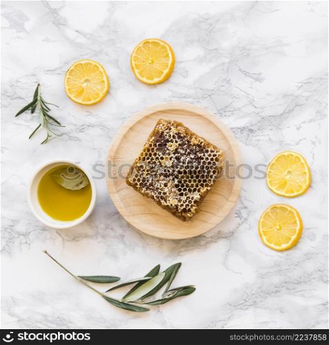lemon slice twig with honeycomb bowl oil white marble background