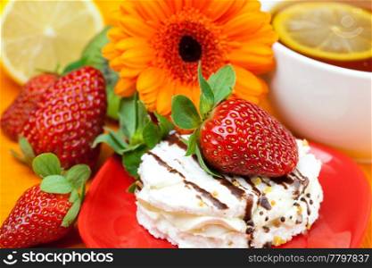 lemon tea ,lemon,gerbera,cake and strawberries lying on the orange fabric