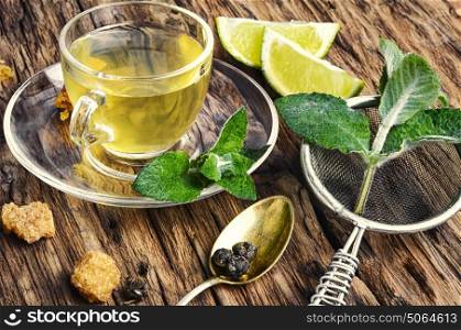Lemon tea on wood background. Tea with lemon and mint on the retro wooden background