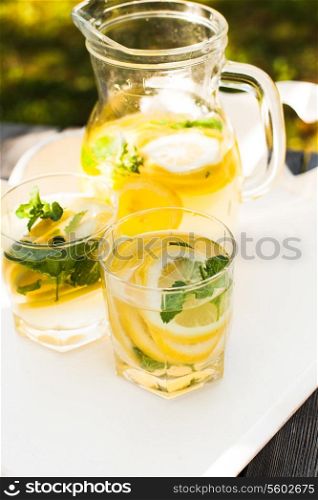 Lemonade drink in the glasses and jug on the white tray
