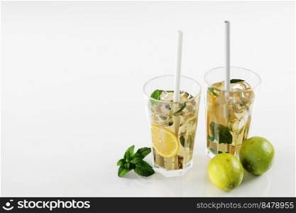 Lemonade, limes and mint leaves on white background. refreshing drinks concept