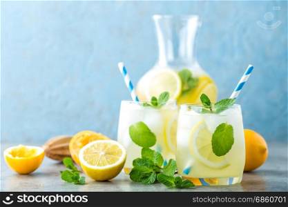 Lemonade or mojito cocktail with lemon and mint, cold refreshing drink or beverage with ice