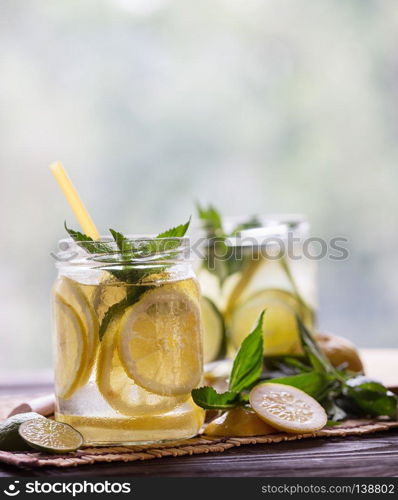 Lemonade with mint and lemon slices on wooden background. Lemonade with mint and lemon slices