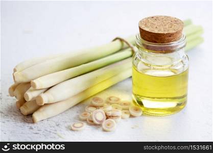 lemongrass essential oil and fresh sliced lemongrass on the white marble table, aromatherapy concept