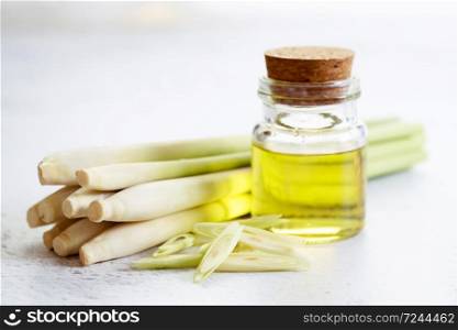 lemongrass essential oil and fresh sliced lemongrass on the white marble table, aromatherapy concept