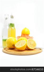Lemons as ingredients to lemonade, bottles and fruit sqeezer