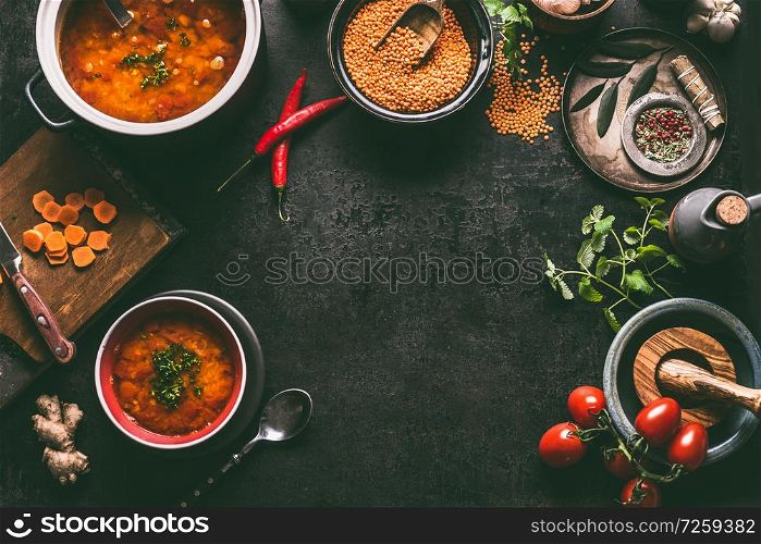 Lentil dishes food background. Lentil soup with cooking ingredients on dark rustic kitchen table background, top view. Healthy vegan food concept. Blank cutting board and vegetarian lentil meal