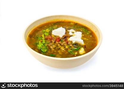 Lentil soup with spinach, tomatoes and feta cheese in a yellow dish isolated on white background