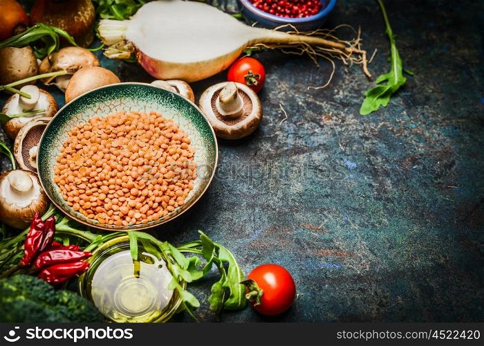 Lentil with fresh vegetables and ingredients for cooking on blue rustic background, close up. Vegan food , vegetarian , diet or healthily cooking concept.