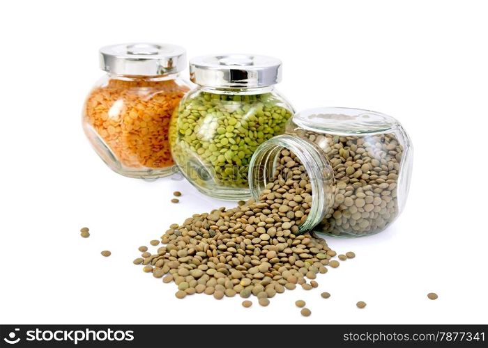 Lentils green, red, brown glass jars in a row isolated on white background