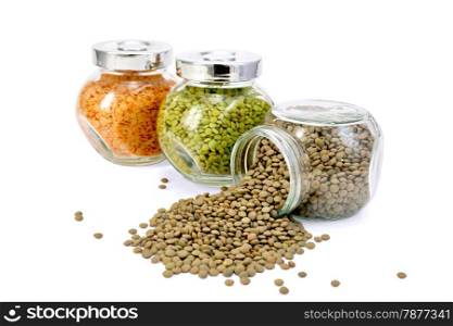 Lentils green, red, brown glass jars in a row isolated on white background