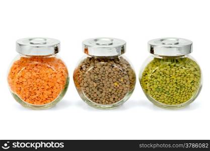 Lentils red, green, brown in glass jars isolated on white background