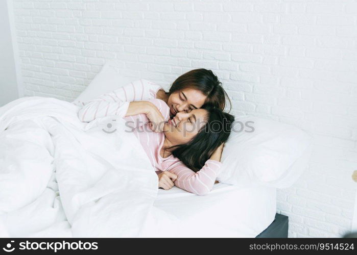 Lesbian couple homosexual happiness lifestyle on bed. Two pretty girlfriend talk, hug and laugh together relation fall in love. LGBTQ relation lifestyle concept.