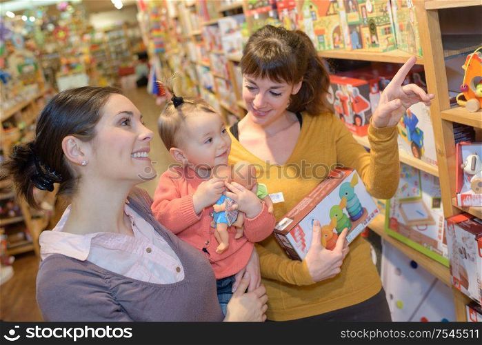 lesbian couple with daughter buying toys