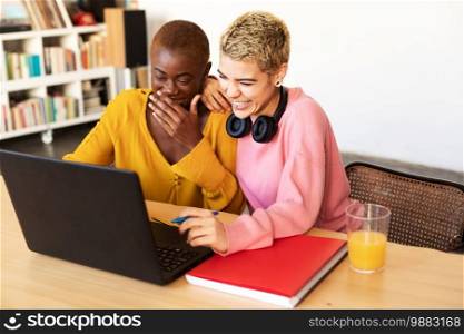 Lesbian couple with laptop on table at home