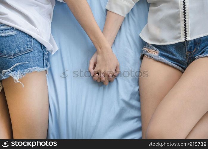 Lesbians sleeping and holding hands on bed together. Lifestyles and People concept. Love of homosexual theme. LGBT and Valentines day theme.