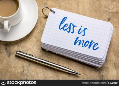 less is more - handwriting on a stack of index cards with a cup of coffee and a pen, minimalism concept