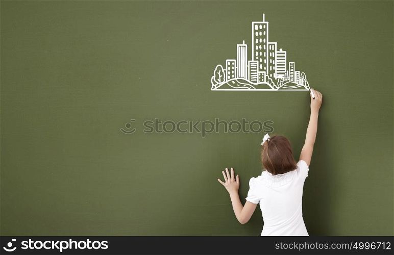 Lesson at school. Cute girl of school age writing with chalk on blackboard
