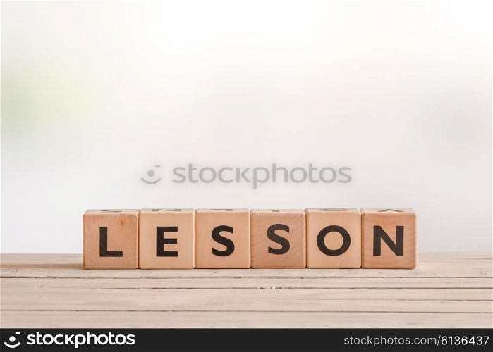 Lesson word spelled with cubes on a wooden table