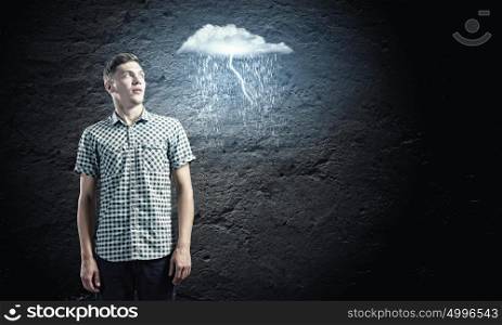 Let it rain. Young man looking at illustration of raining cloud