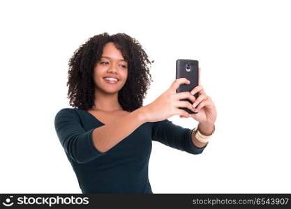 Let me take a selfie!. Happy young woman taking self portrait photography through smart phone over white background.
