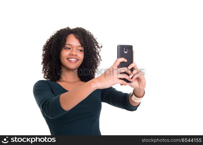 Let me take a selfie!. Happy young woman taking self portrait photography through smart phone over white background.