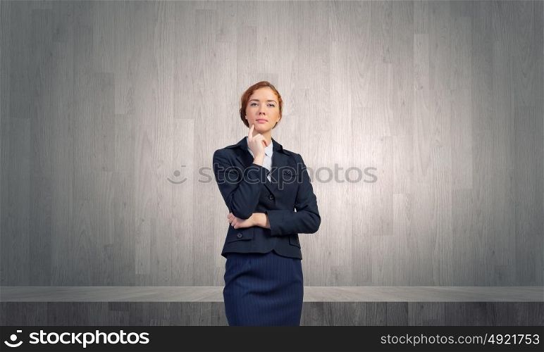 Let me think. Young thoughtful businesswoman with finger on chin